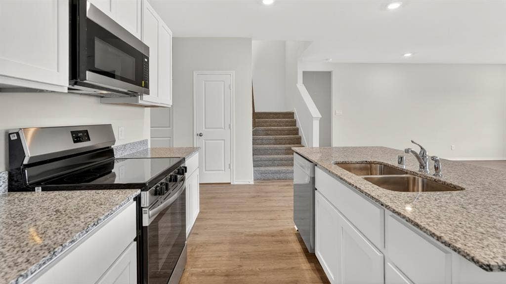 237 Yates Street, Bullard, TX 75757 Kitchen featuring white cabinetry, stainless steel appliances, granite countertops, and wood-finish flooring