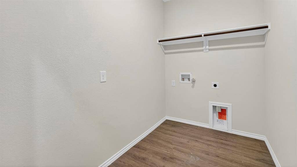 237 Yates Street, Bullard, TX 75757 Utility area featuring wood-finish flooring, a built-in shelf with a hanging rod, and appliance hookups