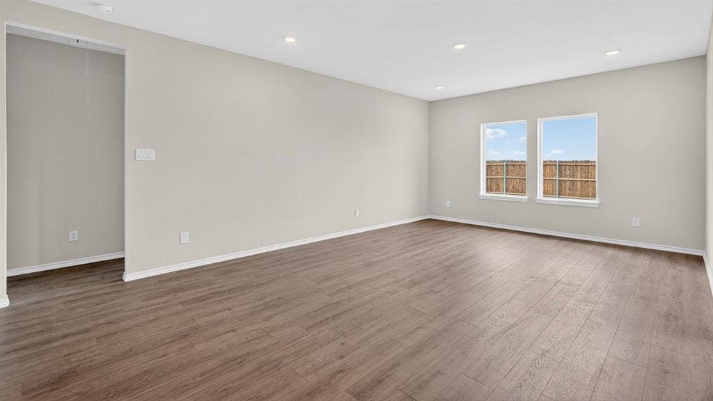 237 Yates Street, Bullard, TX 75757 Spacious room featuring wood-finish flooring, light neutral walls, recessed lighting, and two windows