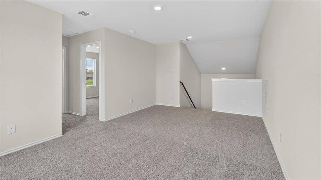 237 Yates Street, Bullard, TX 75757 Spacious carpeted area with neutral wall tones, recessed lighting, and a white balustrade