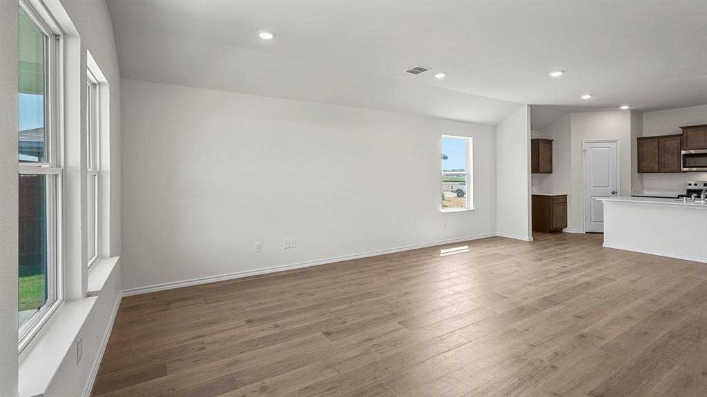 185 Brooks Street, Bullard, TX 75757 Expansive open concept living area with wood-finish flooring, vaulted ceiling, and recessed lighting