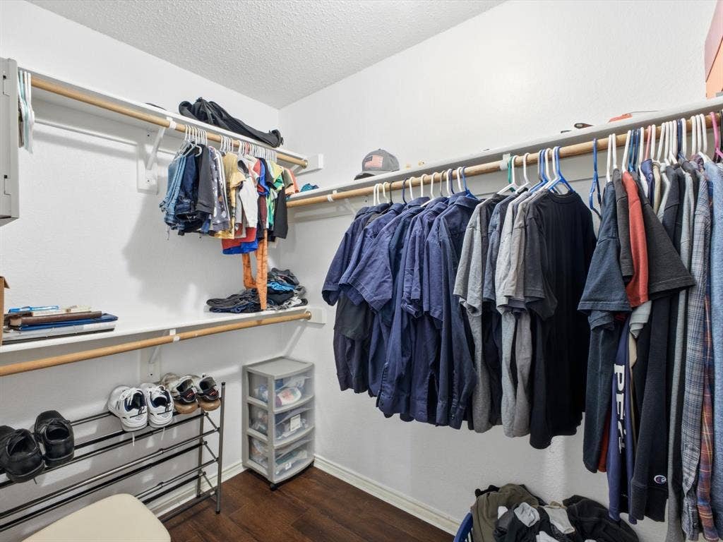 2001 Waleska Plaza, Dallas, TX 75211 Walk-in closet featuring wood-finish flooring, multiple shelving units, and integrated hanging rods