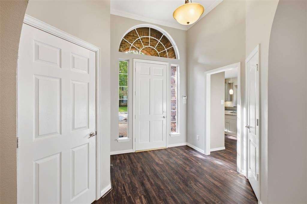 14616 Vintage Lane, Addison, TX 75001 Arched transom and full sidelights pour daylight into a soaring entry — the whole home starts bright