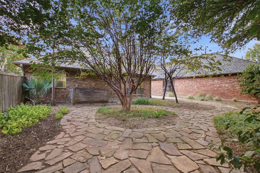 14616 Vintage Lane, Addison, TX 75001 Fully fenced yard with a winding flagstone path and mature trees