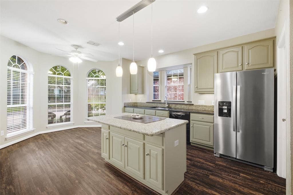 14616 Vintage Lane, Addison, TX 75001 Chef's kitchen, 14'9" x 19' — granite island cooktop, stainless appliances and a bay of arched windows