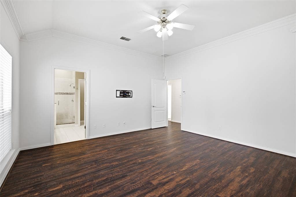 14616 Vintage Lane, Addison, TX 75001 Vaulted ceiling with crown molding, dark wood-finish flooring, ceiling fan with integrated lighting, and an additional room accessible through a doorway