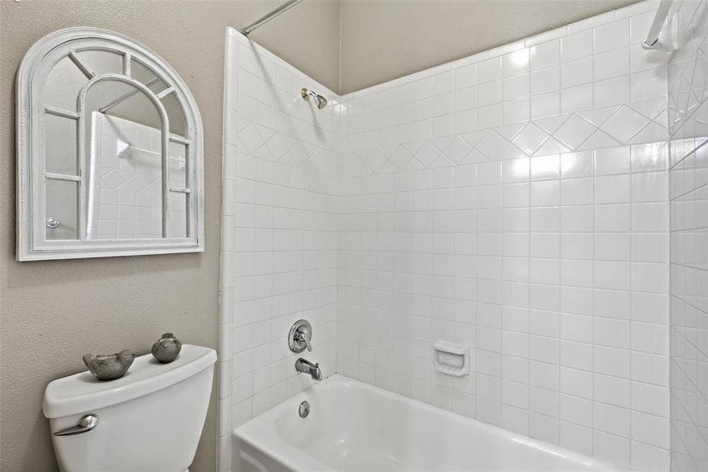 14616 Vintage Lane, Addison, TX 75001 Crisp tub-and-shower combo with full tile surround, clean and ready for guests