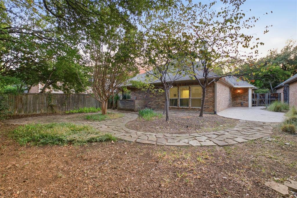 14616 Vintage Lane, Addison, TX 75001 Golden hour on classic brick and a sweeping stamped-concrete patio built for entertaining