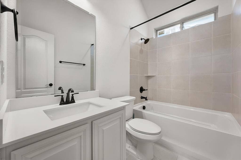 5626 Rutherford Drive, Midlothian, TX 76065 Full bath — oil-rubbed bronze fixtures, a deep soaking tub, and the window up top lets in natural light without sacrificing privacy.