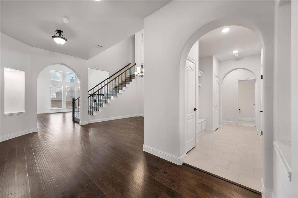 5626 Rutherford Drive, Midlothian, TX 76065 Here's a great shot of the staircase with its wrought-iron railings, and off to the right, you can see the hallway heading back toward the mudroom and garage entry.