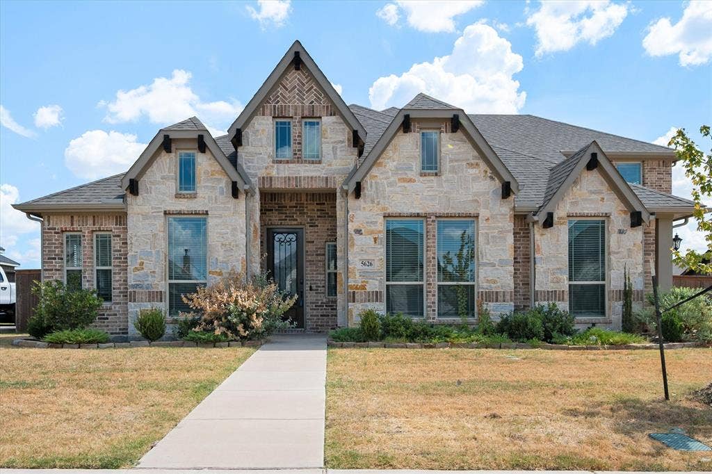 5626 Rutherford Drive, Midlothian, TX 76065 Look at that stone and brick facade — the steep, layered gables just give it so much curb appeal. Gorgeous iron-and-glass front door.