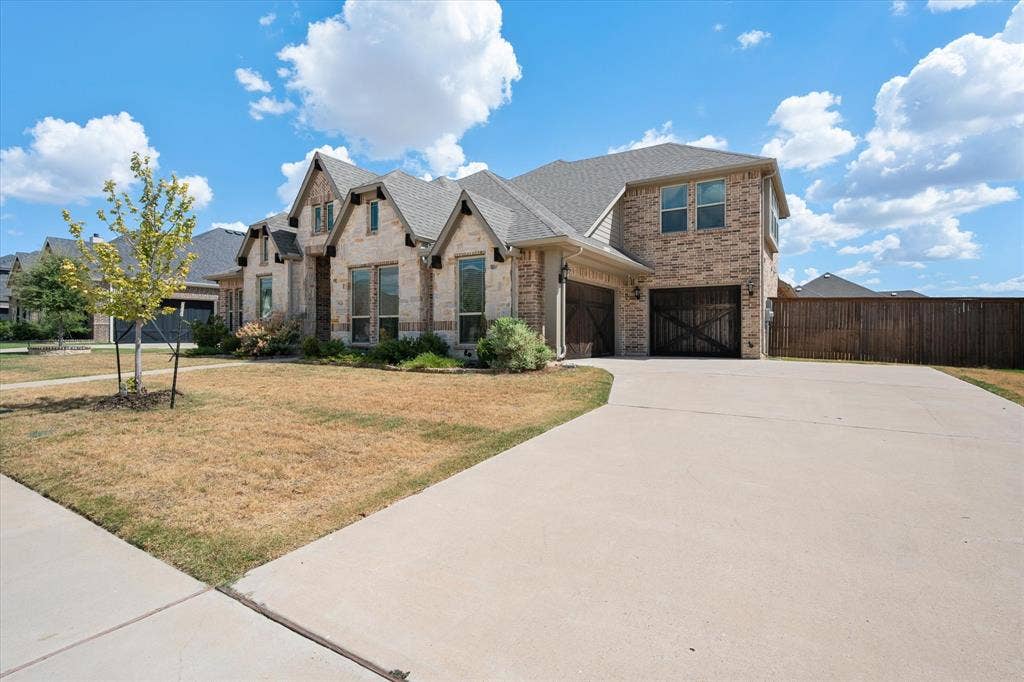 5626 Rutherford Drive, Midlothian, TX 76065 Here's your driveway and garage — plenty of space to park, with that same beautiful stone and brick carrying all the way across the front elevation.