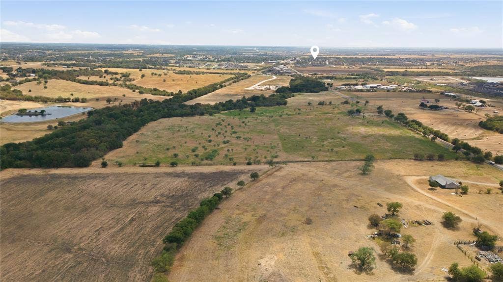 TBD N Louisiana Drive, Celina, TX 75009 Expansive acreage featuring a natural pond, wooded areas, and open fields with surrounding infrastructure