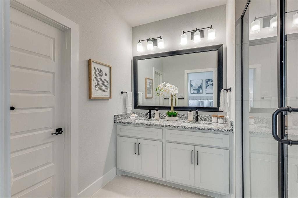 505 Mission Trail, #603, Arlington, TX 76010 Double vanity with granite countertop, white cabinetry, and matte black hardware