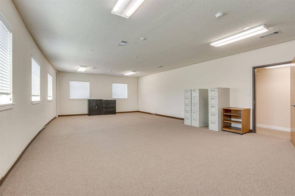 1415 E Belt Line Road, Carrollton, TX 75006 Spacious room with carpet flooring, multiple rectangular windows, recessed lighting, and a neutral color palette