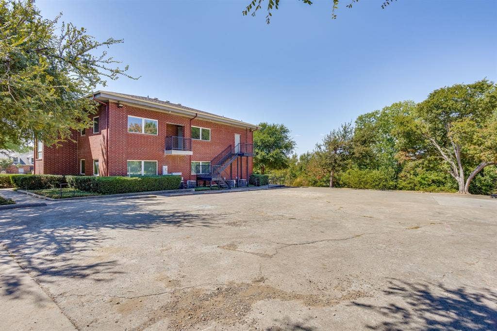 1415 E Belt Line Road, Carrollton, TX 75006 Brick exterior building with multiple windows, featuring a balcony and an exterior staircase