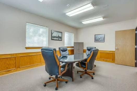 1415 E Belt Line Road, Carrollton, TX 75006 Carpeted flooring with wood paneling and white walls, featuring multiple windows with blinds and overhead fluorescent lighting