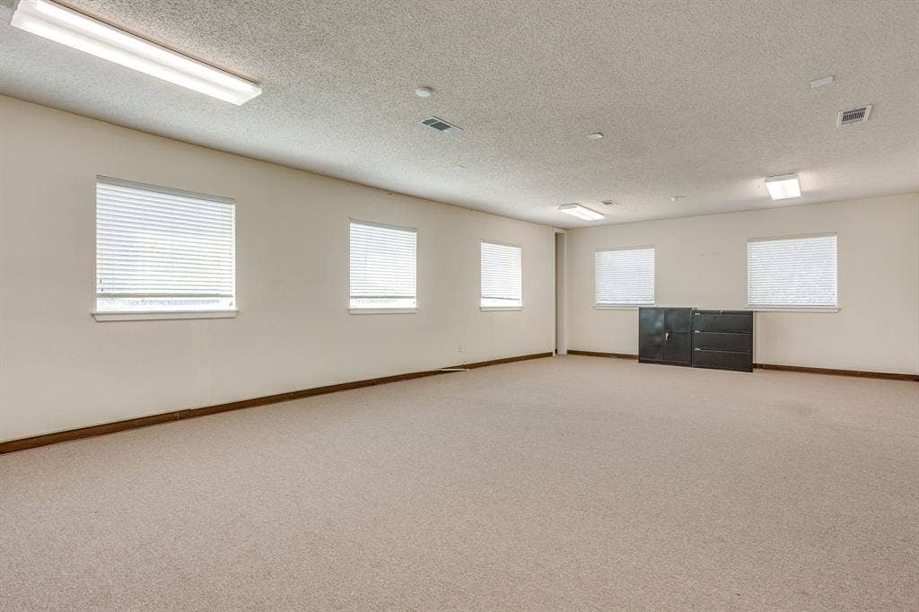 1415 E Belt Line Road, Carrollton, TX 75006 Spacious room with multiple windows, neutral carpet flooring, and recessed lighting