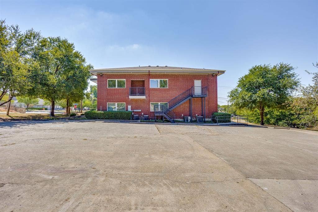 1415 E Belt Line Road, Carrollton, TX 75006 Brick exterior with multiple windows and an exterior metal staircase