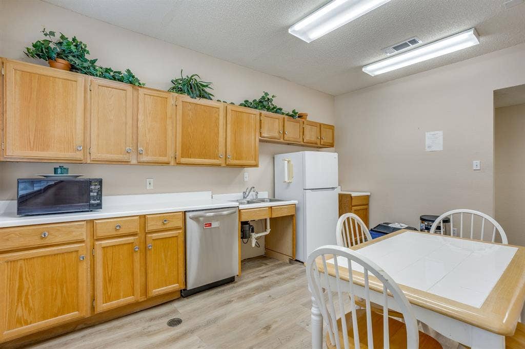 1415 E Belt Line Road, Carrollton, TX 75006 Wood-finish flooring, ample cabinetry, white countertops, built-in dishwasher, and a stainless steel sink