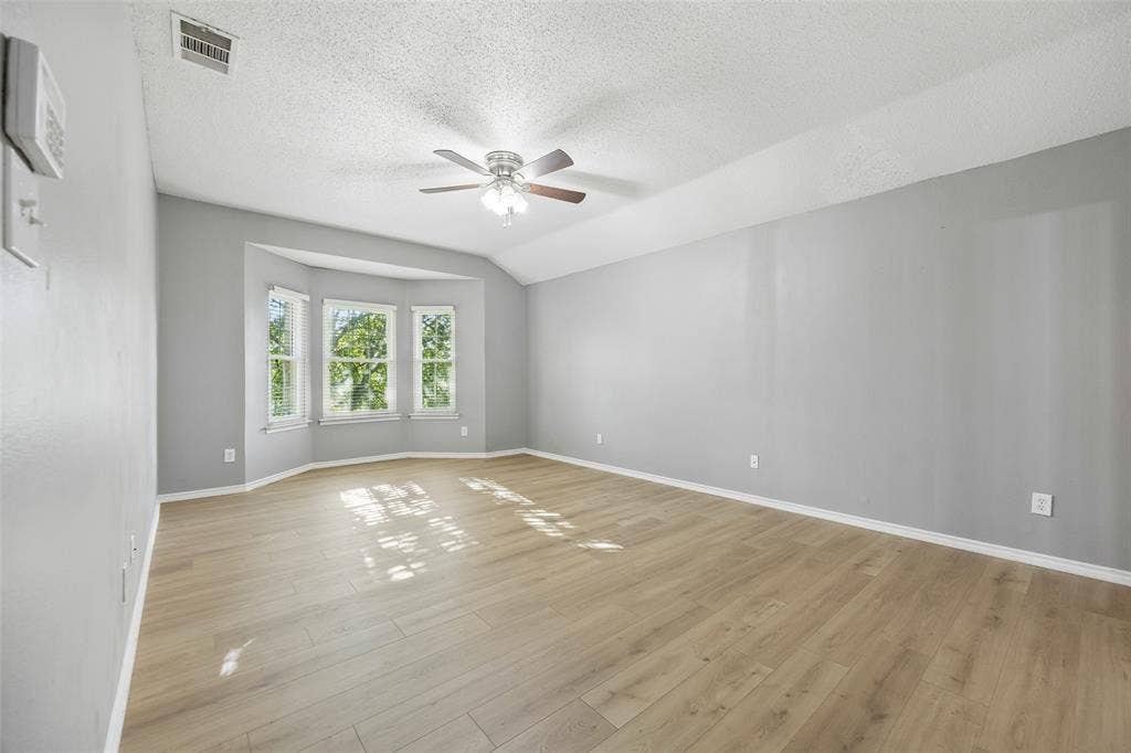 753 Summerfield Drive, Allen, TX 75002 Vaulted ceiling, ceiling fan, wood-finish flooring, bay window, and light gray wall paint