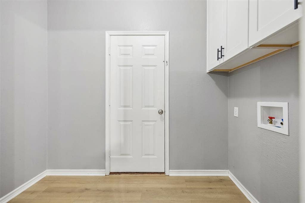 753 Summerfield Drive, Allen, TX 75002 White paneled door with a silver knob, wood-finish flooring, and crisp white trim