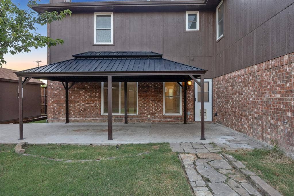 753 Summerfield Drive, Allen, TX 75002 Spacious concrete patio with a tiered metal gazebo, brick exterior, and a stone walkway
