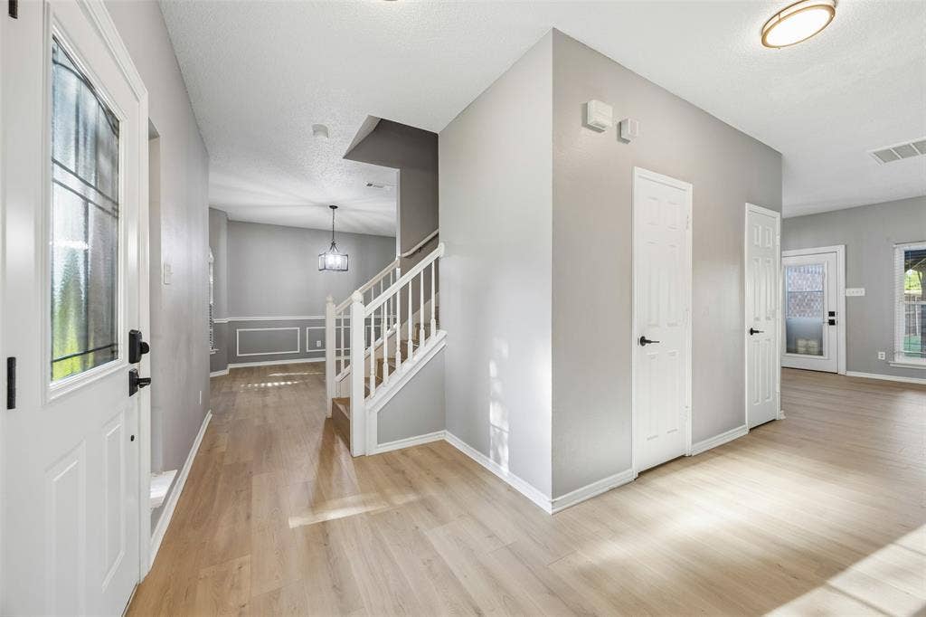 753 Summerfield Drive, Allen, TX 75002 Entryway with wood-finish flooring, white paneled doors, staircase with white railing, and flush-mount ceiling lighting