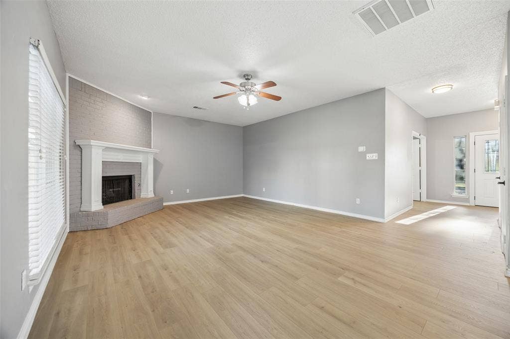 753 Summerfield Drive, Allen, TX 75002 Spacious interior with wood-finish flooring, a painted brick fireplace with a white mantel, and a ceiling fan