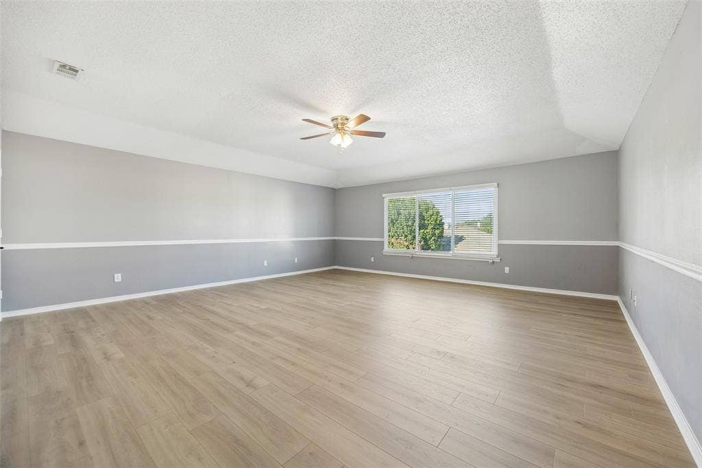 753 Summerfield Drive, Allen, TX 75002 Spacious room featuring wood-finish flooring, a contemporary ceiling fan, and a large window