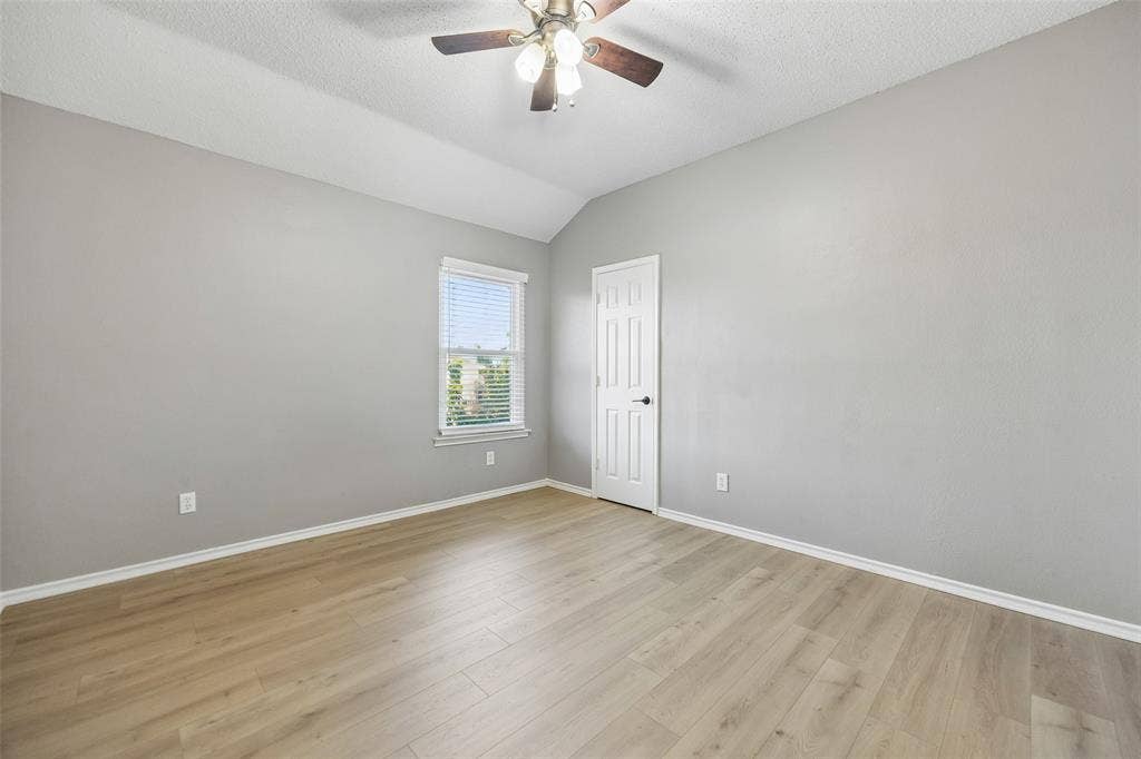 753 Summerfield Drive, Allen, TX 75002 Vaulted ceiling with a ceiling fan, wood-finish flooring, and a paneled door