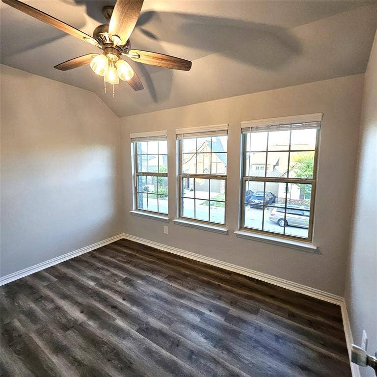 2225 Crooked Bow Drive, Mesquite, TX 75149 Vaulted ceiling featuring a ceiling fan with integrated lighting, wood-finish flooring, and multiple grid-pattern windows