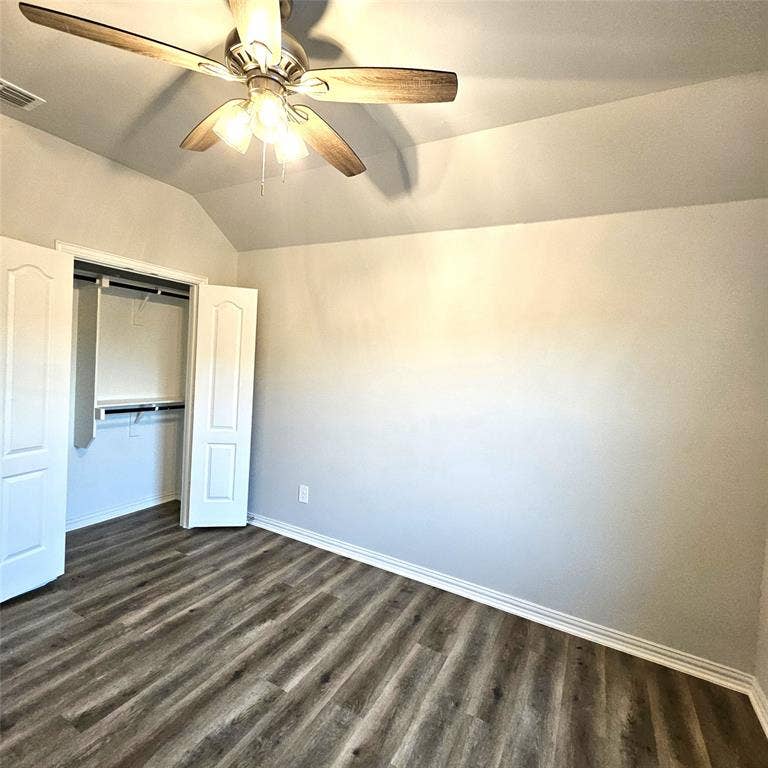 2225 Crooked Bow Drive, Mesquite, TX 75149 Vaulted ceiling featuring a ceiling fan with integrated lighting, wood-finish flooring, and a closet with bifold doors