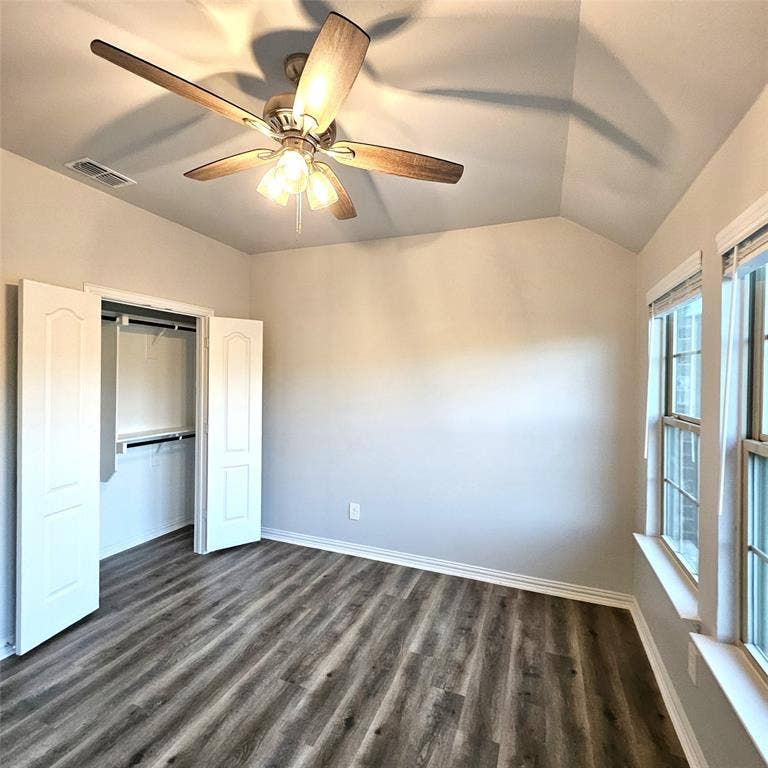 2225 Crooked Bow Drive, Mesquite, TX 75149 Vaulted ceiling with an attached ceiling fan and light fixture, wood-finish flooring, and a built-in closet with double doors