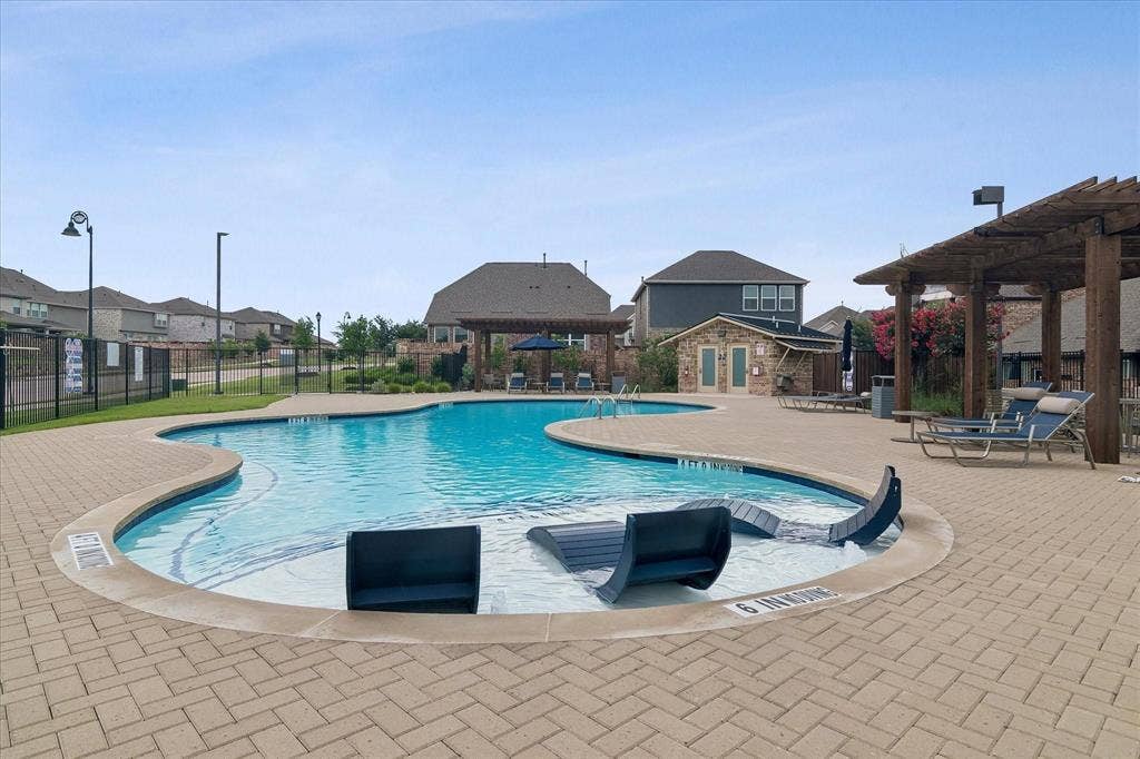 2225 Crooked Bow Drive, Mesquite, TX 75149 Resort-style swimming pool featuring an irregular shape, a sun shelf, and integrated lounge seating