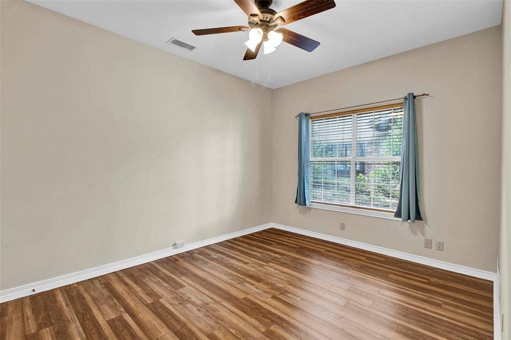 1551 E Tanglewood, Hideaway, TX 75771 Wood-finish flooring, neutral wall tones, and a window with horizontal blinds