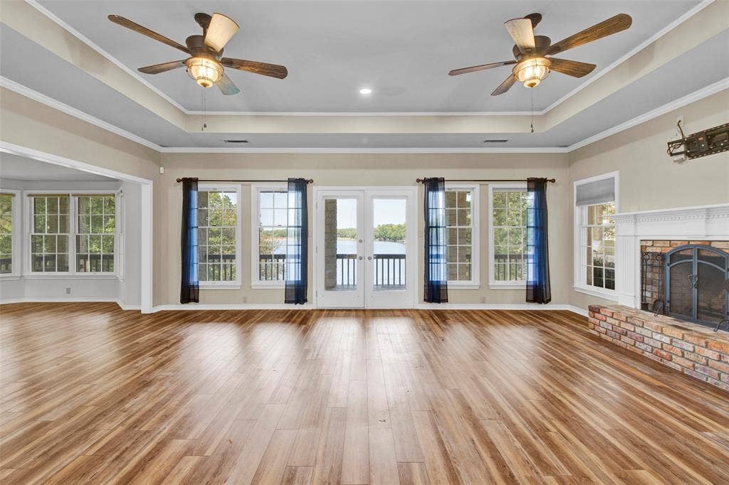 1551 E Tanglewood, Hideaway, TX 75771 Expansive wood-finish flooring, dual ceiling fans, and a brick fireplace