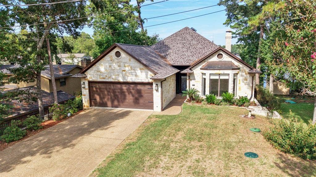 1551 E Tanglewood, Hideaway, TX 75771 Stone exterior with a shingle roof and an attached two-car garage