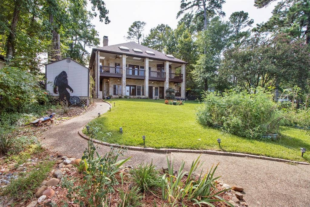 1551 E Tanglewood, Hideaway, TX 75771 Stone-clad exterior with multiple balconies, a dormer window roof, and a prominent chimney