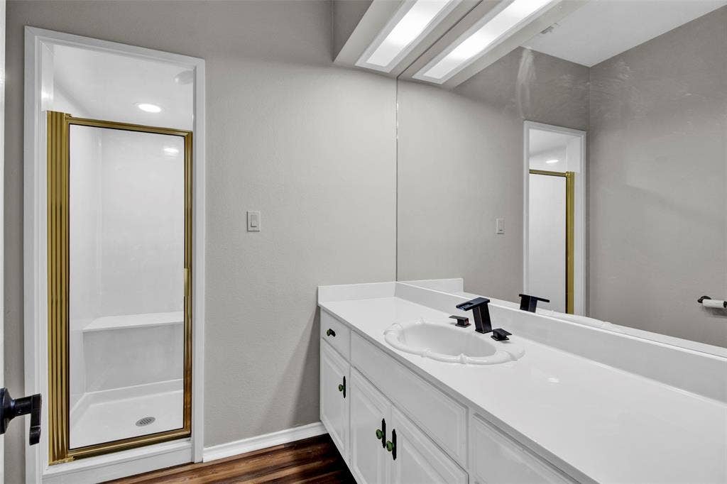 1551 E Tanglewood, Hideaway, TX 75771 Vanity with an integrated sink, black hardware, and a framed mirror
