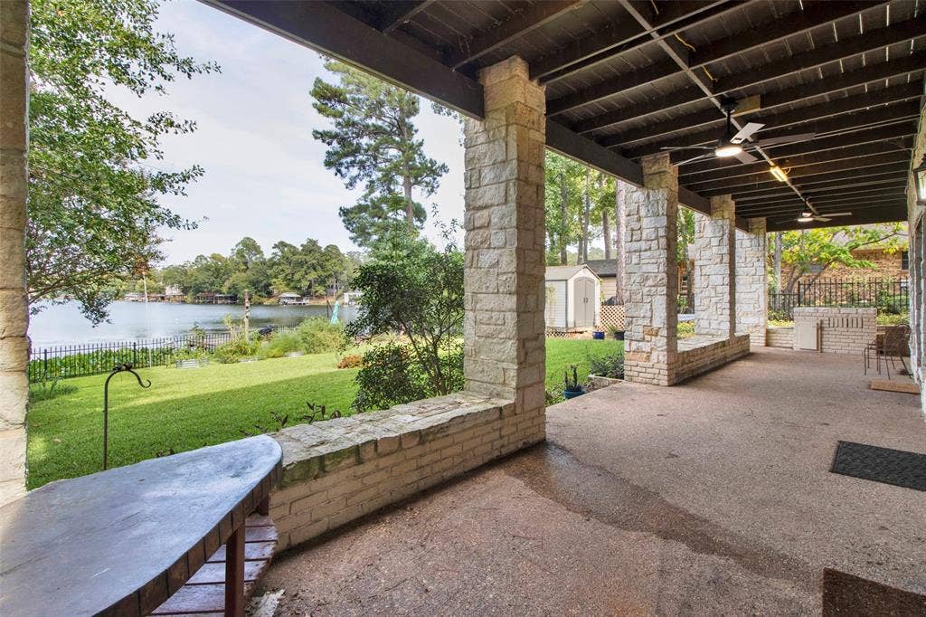 1551 E Tanglewood, Hideaway, TX 75771 Expansive covered patio with stone columns, concrete flooring, and ceiling fans