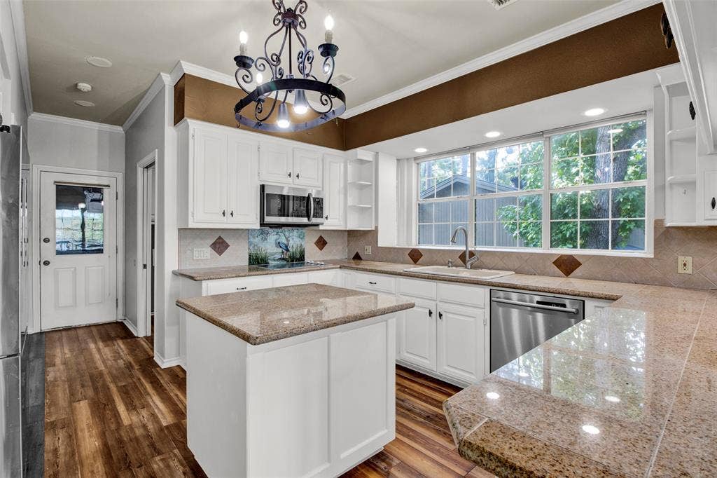 1551 E Tanglewood, Hideaway, TX 75771 Kitchen featuring white cabinetry, granite-finish countertops, stainless steel appliances, a center island, and wood-finish flooring
