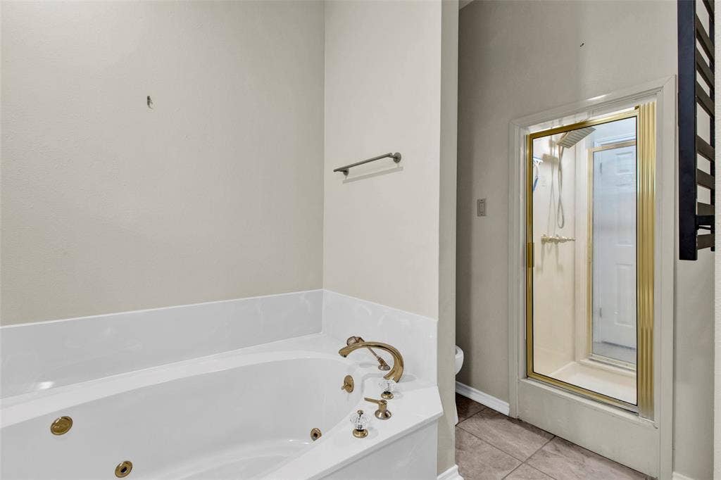 1551 E Tanglewood, Hideaway, TX 75771 White jetted soaking tub with brass fixtures