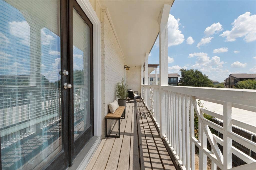 5934 Sandhurst Lane, #208, Dallas, TX 75206 Private balcony with wood-finish decking, white painted brick exterior, and white architectural railings