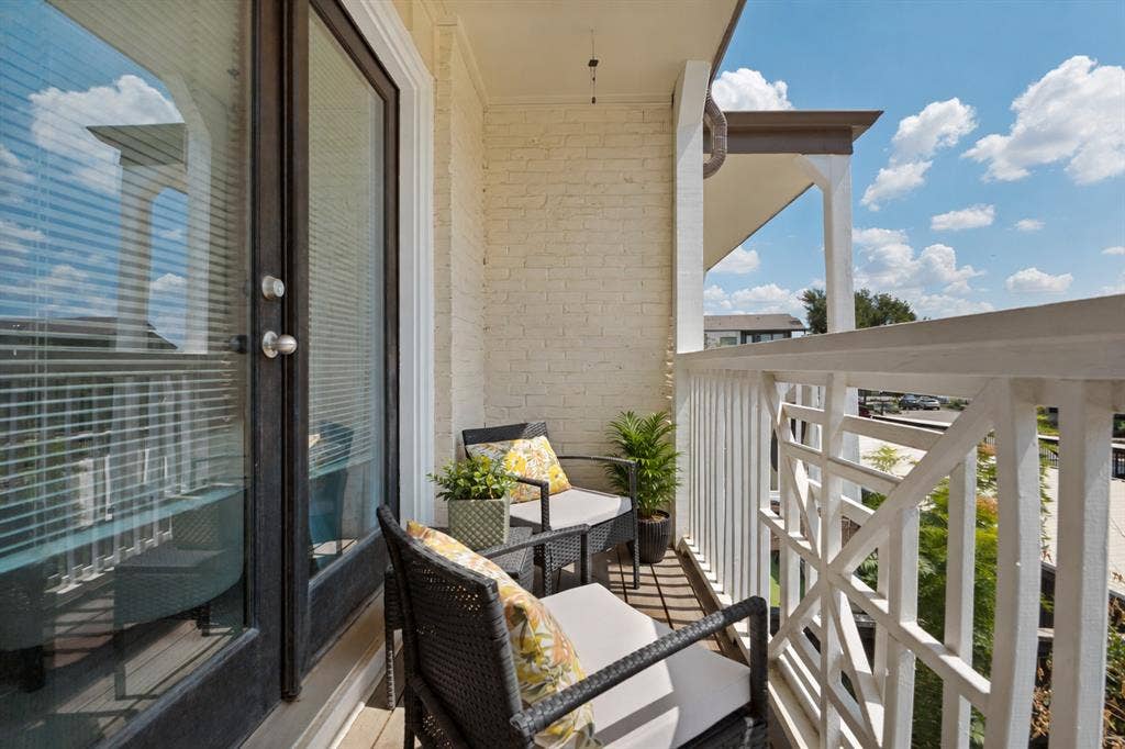 5934 Sandhurst Lane, #208, Dallas, TX 75206 Private balcony with a painted brick exterior, white balusters, and a decorative railing panel