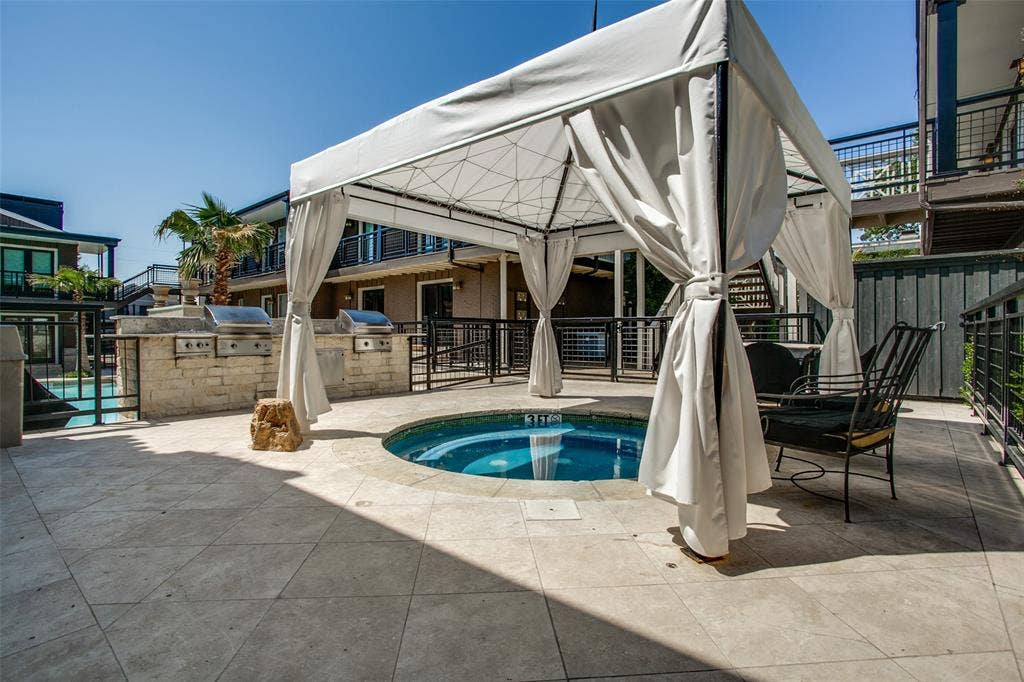 5934 Sandhurst Lane, #208, Dallas, TX 75206 Paved patio with an in-ground spa, a freestanding gazebo, and a built-in outdoor kitchen featuring two stainless steel grills