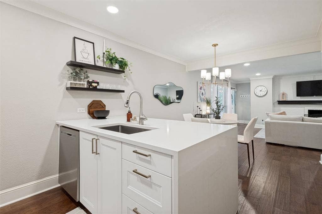 5934 Sandhurst Lane, #208, Dallas, TX 75206 Kitchen island with white cabinetry, stainless steel dishwasher, and an undermount sink with a gooseneck faucet