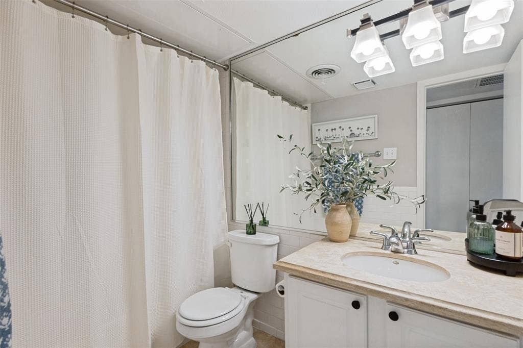 5934 Sandhurst Lane, #208, Dallas, TX 75206 Vanity with an integrated sink, a polished chrome faucet, under-cabinet storage, and a light-toned countertop