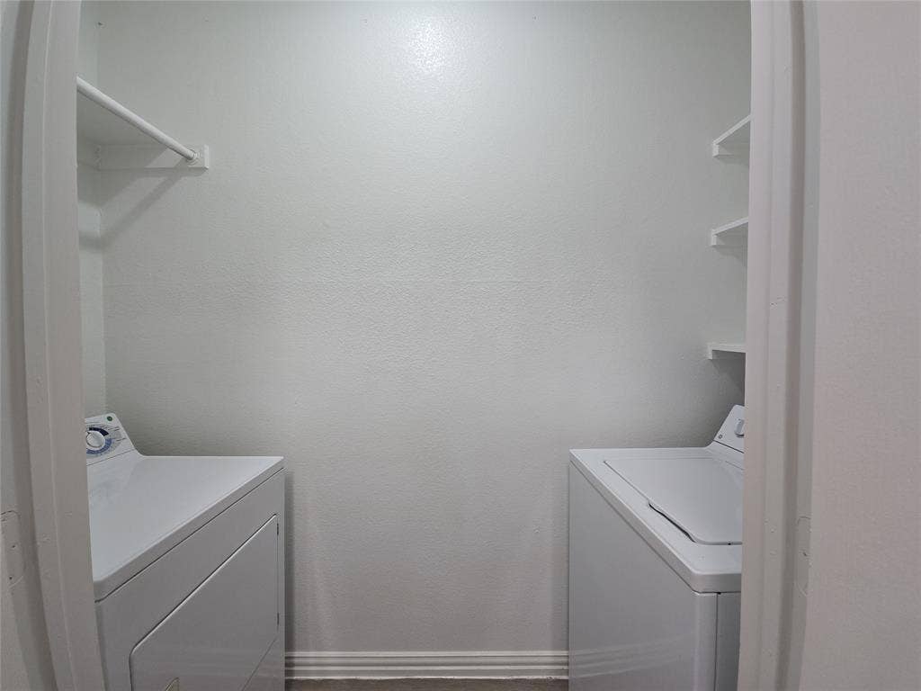 1501 Cedar Elm Drive, #102, Euless, TX 76039 Laundry area featuring white walls, a built-in shelving unit, and a clothes rod