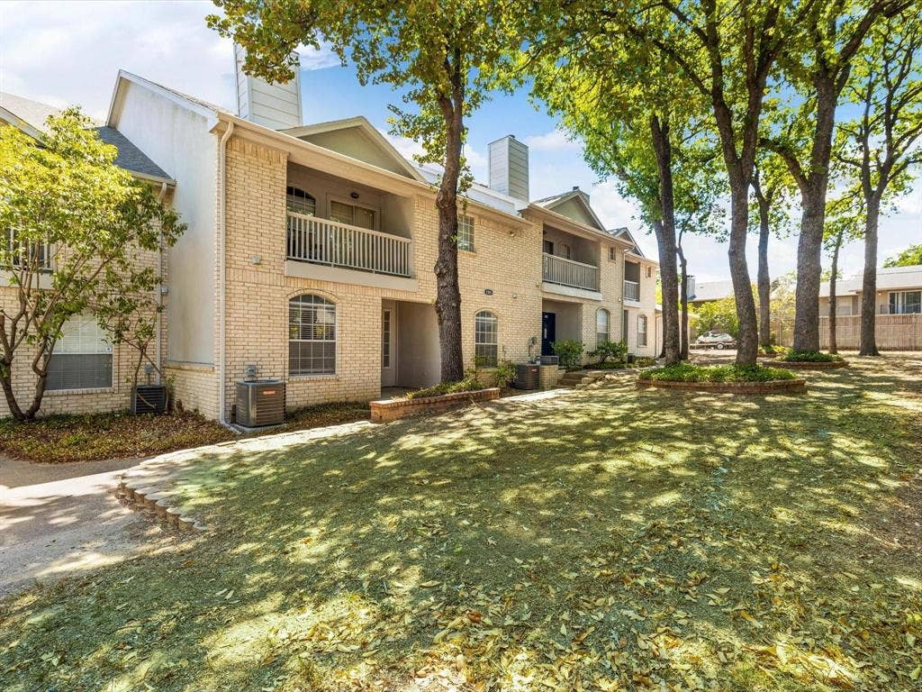 1501 Cedar Elm Drive, #102, Euless, TX 76039 Brick exterior with white trim, arched windows, and second-story balcony